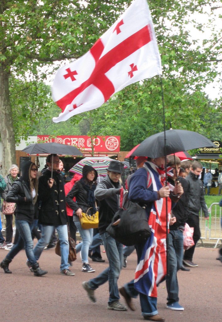 Jubilee weekend.  Brollies are up for a moment but the crowds don't care.  Notice the layers of clothing. Photo by me